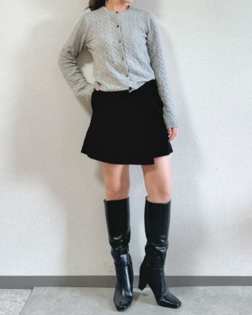 グレーのケーブルクルーネックカーディガンを着たコーデ