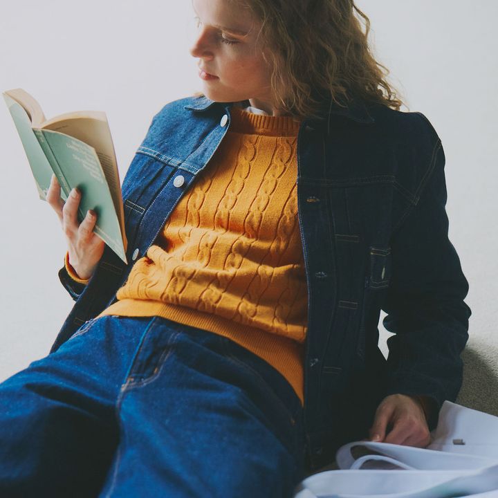 オレンジのニットをジャケットの中からのぞかせるパリジェンヌみたいなデニムオンデニ ムスタイル