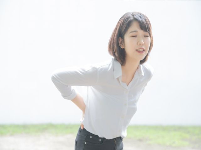 腰をおさえる女性