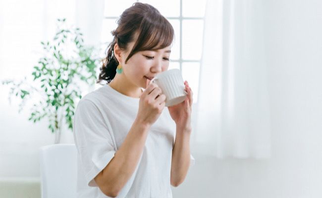 温かい飲み物を飲む女性