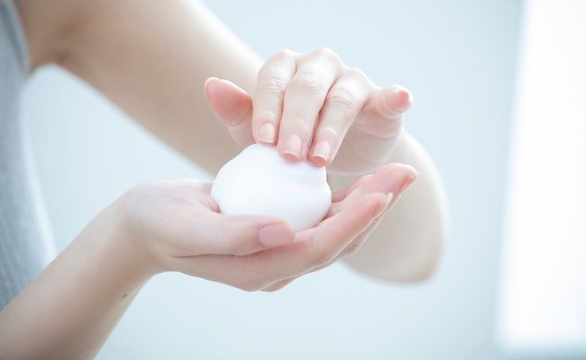 洗顔料を泡立てる女性