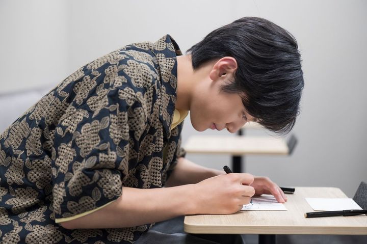 読者のかたへ向けた直筆メッセージを書く際も、真剣なまなざし。