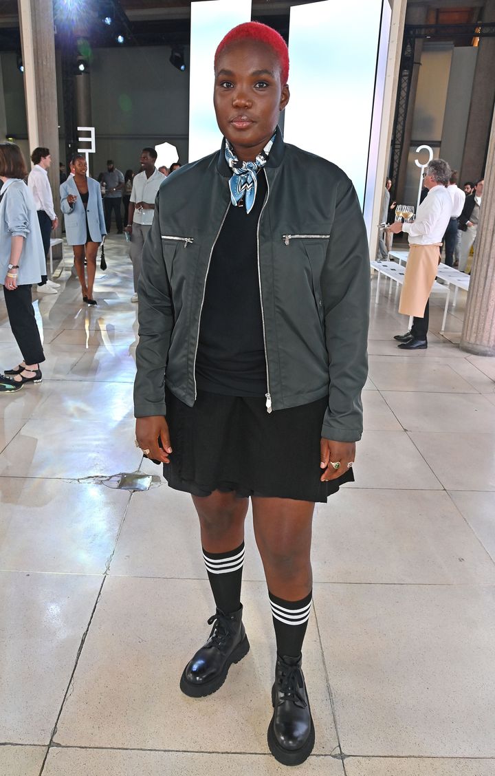 2025年春夏パリファッションウィークにて、エルメスのメンズショーに出席したアーロ・パークス。小さなブルーのスカーフを添えて、鮮やかなレッドヘアとのコントラストをプラスした。