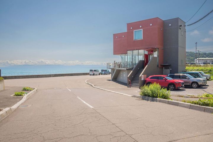 海に向かう坂道を下ると見えてくる「カフェラミネール」。階段をのぼった2階が店舗の入り口