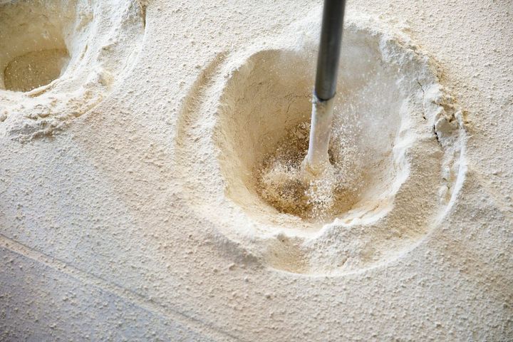 スタンパーと呼ばれる機械で、叩くようにして花坂陶石を砕いていく。