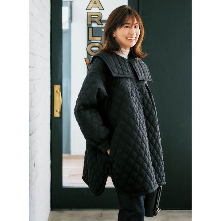 大きな襟がついた黒のキルティングコートを羽織った東原明希さん