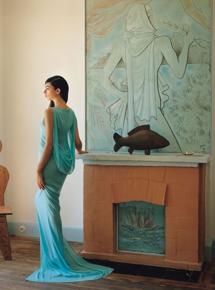 別のゲストルームで、ジャン・コクトーの絵画2点の横で光を浴びるディーヴァ・カッセル。 ドレス／JACQUEMUS（www. jacquemus.com）