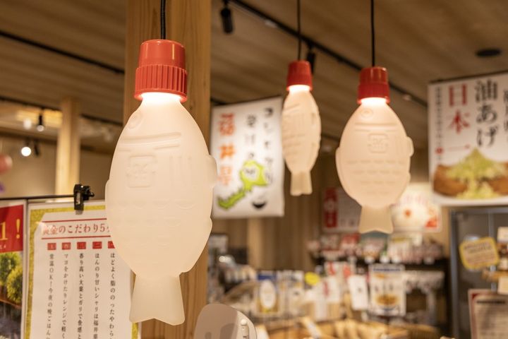 里エリアの総菜コーナーには、魚のしょうゆ入れの形をしたユニークな照明がずらり