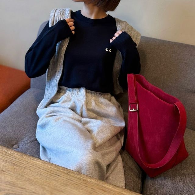 メリノクルーネックセーターを着ている