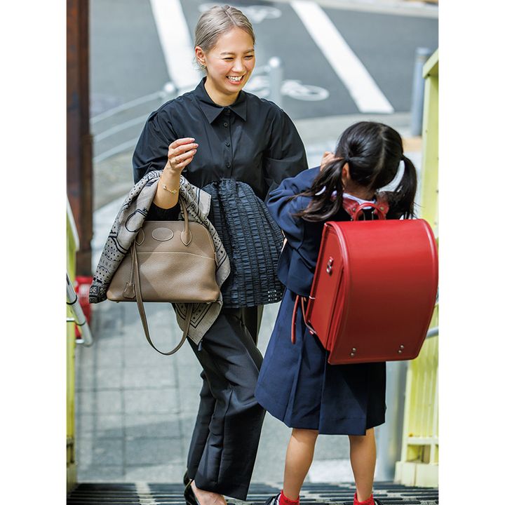 小学生の子どもに微笑みかけるハイトーンヘアのおしゃれママ