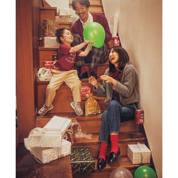 赤チェックのボウタイにグレーのカーデ、青デニムに赤靴下のホリデーコーデ