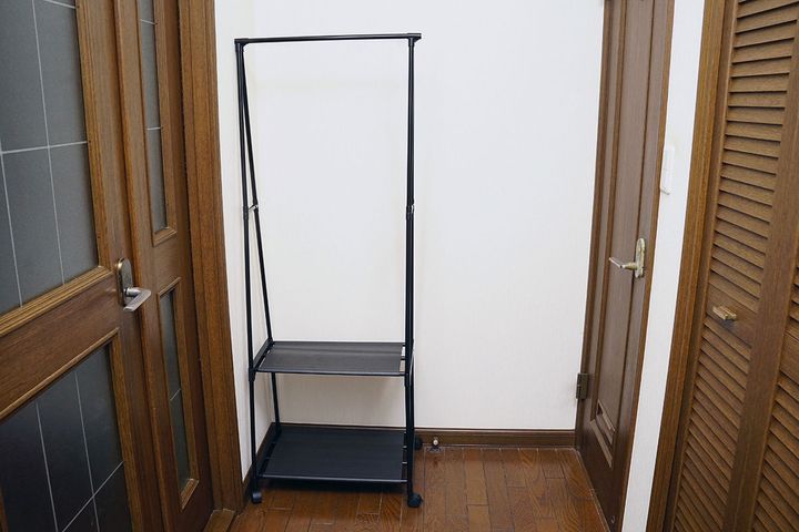 玄関からリビングに向かう廊下の突き当たり、ある意味作り付けのクローゼットのすぐ横に配置した「マルチハンガー」。横幅を調整するために左右の短いパイプは撤去しています。