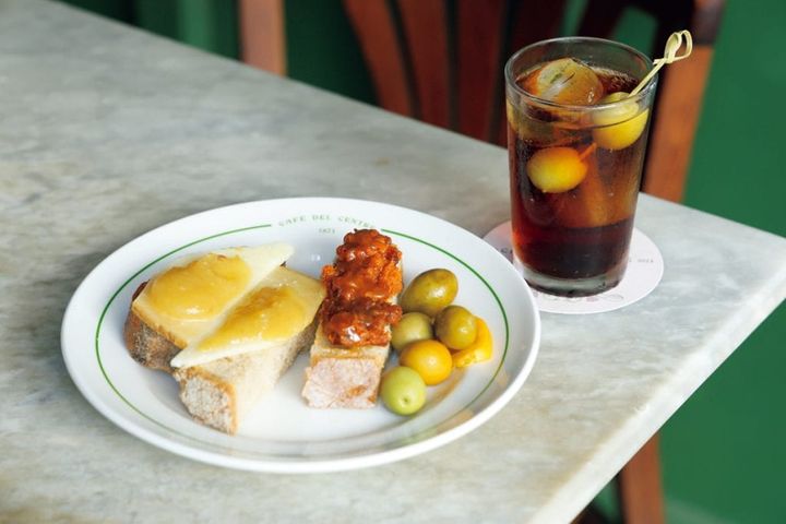 【Café del Centre カフェ・ダル・セントラ】ハーブをワインに漬けたベルムーというスペインの食前酒（€3.8）。バゲットにソブラサーダという熟成サラミのペースト（€13.5）をのせて。