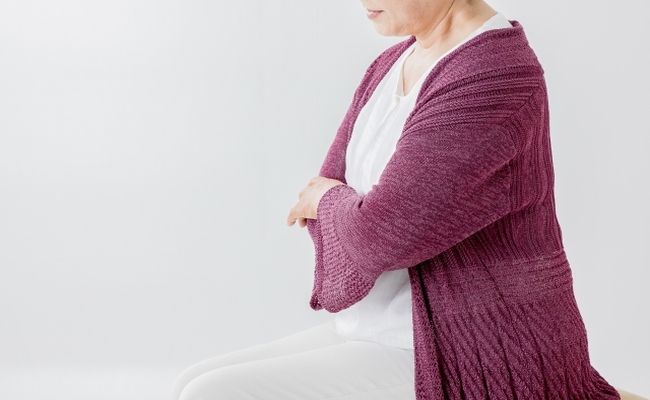 腕組みする高齢者の女性