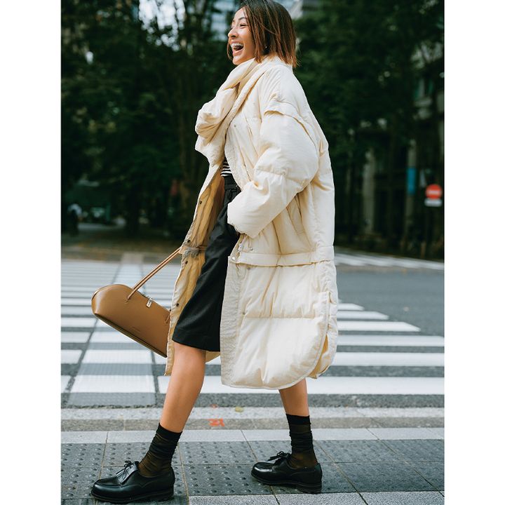 ボーダートップスに黒のハーフパンツにemmiのホワイトダウンを羽織った木佐貫まやさん