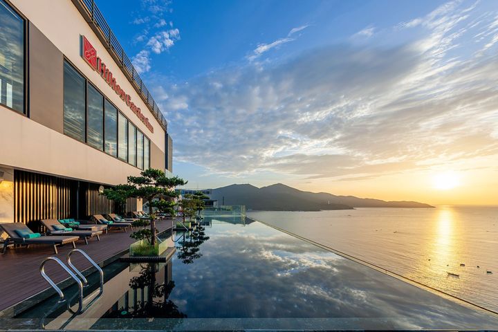 夕陽に輝くルーフトッププールで、心地よい海風に吹かれる。