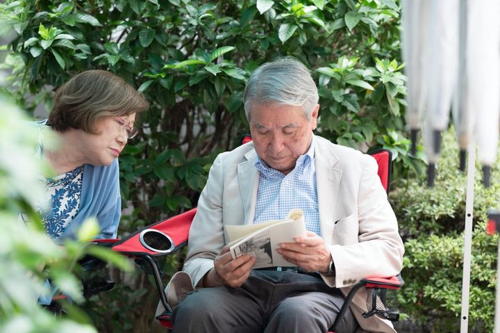 本物のお客さんに見間違うような、リアルなエキストラの方たち。店舗脇のスペースで台本を確認しながら待機します。