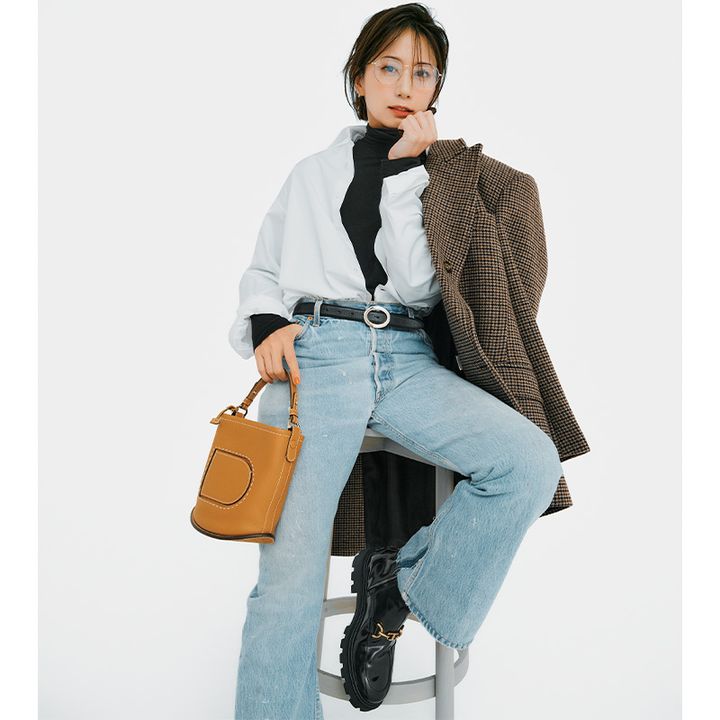 黒タートルとデニムコーデにシャツを羽織ってジャケットを肩掛けした東原亜希さん