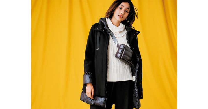 白のニットにヘルノの異素材MIXのダウンコートを羽織ったスポーティコーデ