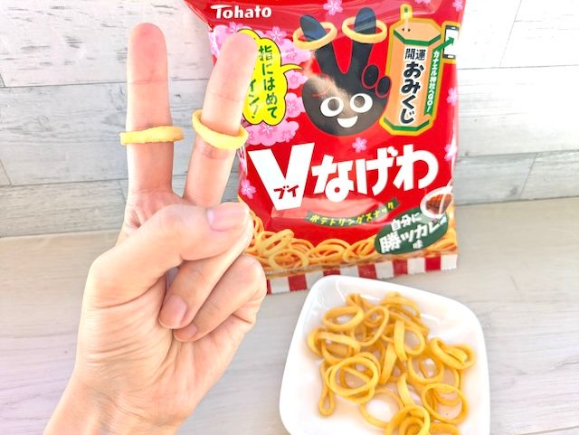 東ハト『Ｖなげわ 自分に勝ツカレー味』指に嵌めてVサイン