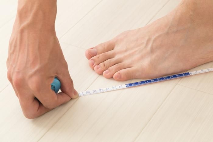 足のサイズを測る人