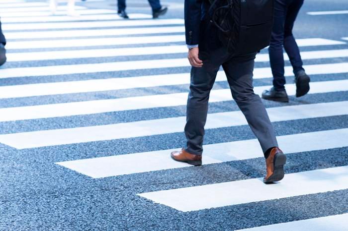 ビジネスシューズを履いて歩く人