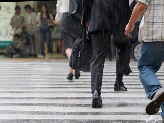 雨の中通勤する人