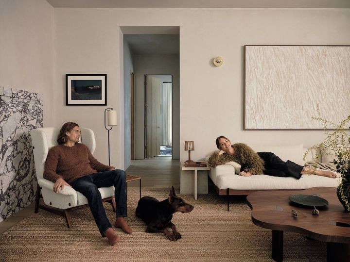 リビングルームでくつろぐテディとアンバー、そして愛犬のヨーロピアン・ドーベルマン・ピンシャーのベラ。配置されているのは、クロフト・ハウスのユニット家具。ウォールナットのローテーブルはルイス・リリエンクランツ。チェアは 1950 年代に作られたジャンフランコ・フラッティーニ、フロアランプは 1960年代のフランス製。