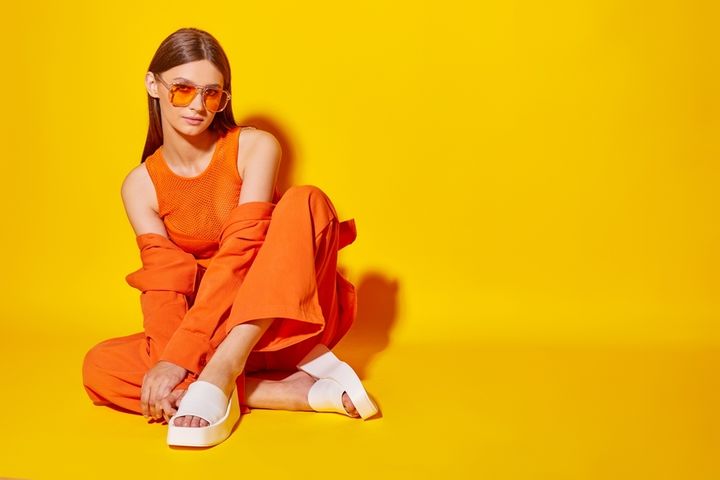 シンプルなビビットオレンジコーデを組む女性