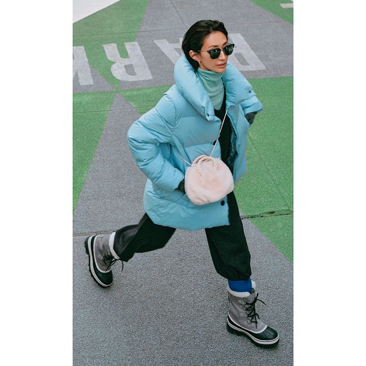 鮮やかカラーのダウンにスノーブーツを履いた完全防寒コーデ。首元もタートルネックで暖か。