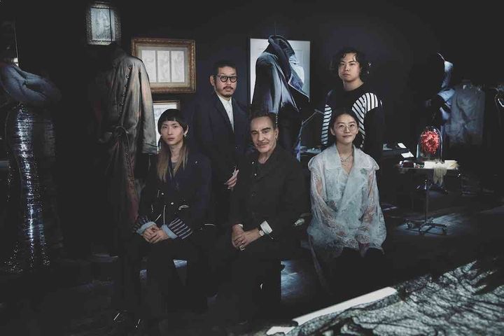 〈前列左〉玉田達也／「Tamme（タム）」デザイナー。文化服装学院服装科、文化ファッション大学院大学を経てパリに留学。帰国後、sacaiでパタンナーとして経験を積んだ後、2021年秋冬にブランドデビュー。ニュートラルな概念による創造と、既存の更新をコンセプトに服作りを行っている。〈後列左〉森永邦彦／「ANREALAGE（アンリアレイジ）」デザイナー。2003年早稲田大学卒業。卒業と同時にブランド設立。「A REAL」（日常）と「UN REAL」（非日常）を行き来する様を、服を通して表現している。2019年に「LVMHプライズ」のファイナリストに選出。2024 - 25年秋冬には「anrealage homme」を創設し、新しい挑戦を続けている。〈前列右〉サカイカナコ／「KANAKO SAKAI（カナコサカイ）」デザイナー。2017年に米パーソンズ美術大学を卒業。国内外のデザイナーブランドで経験を積んだ後、2022年春夏にデビュー。日本の技術や美意識、そして素材にこだわった服作りをモットーにしている。〈後列右〉山本淳／「Jun.y（ジュンワイ）」デザイナー。文化服装学院を卒業。国内ブランドに従事した後、独立。2024年にデビューコレクションを発表。造形美とファンタジーを追求したルックに注目が集まった。