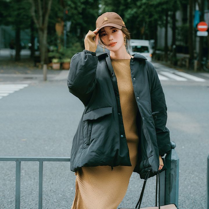 ブラウンのニットワンピースにミラオーウェンの墨黒のダウンコートを羽織りブラウンのキャップを被った咲和希さん