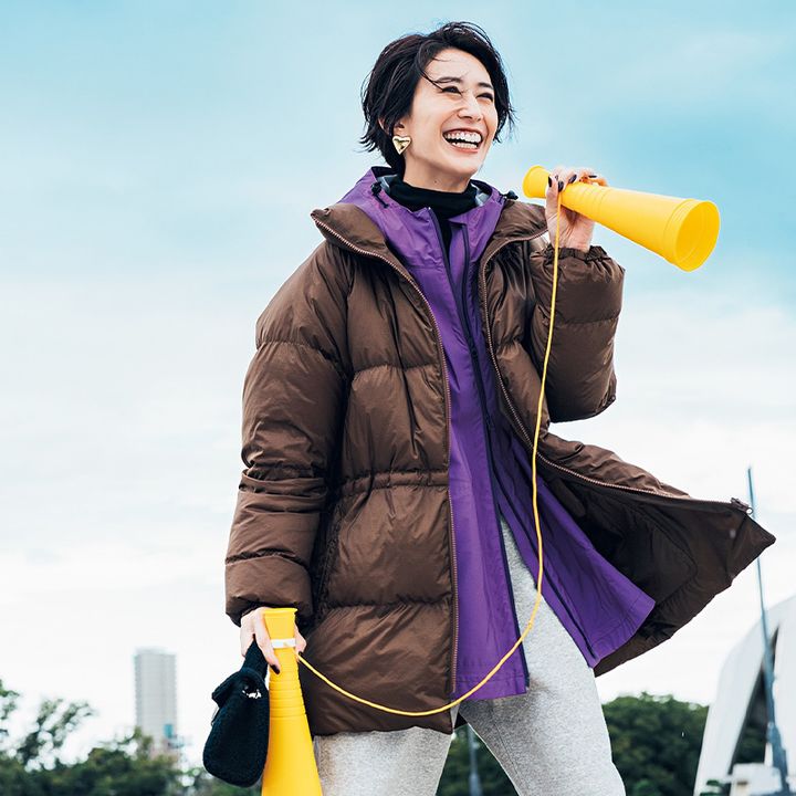 茶色のダウンの下に紫のウィンドブレーカーを重ねてメガホンを持って応援するママ