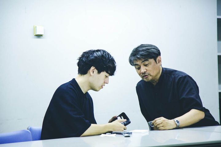 スマホをかざして音楽をシェアする奥山大史と高崎卓馬