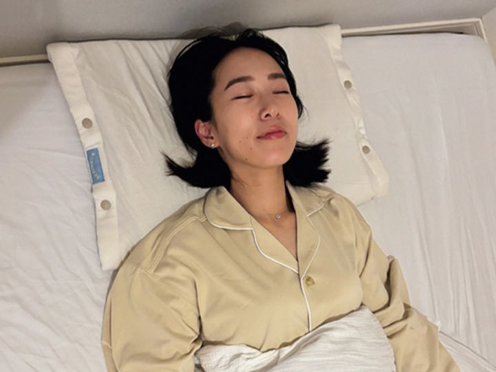 リカバリーウェアを着ながら上向きに寝るママ