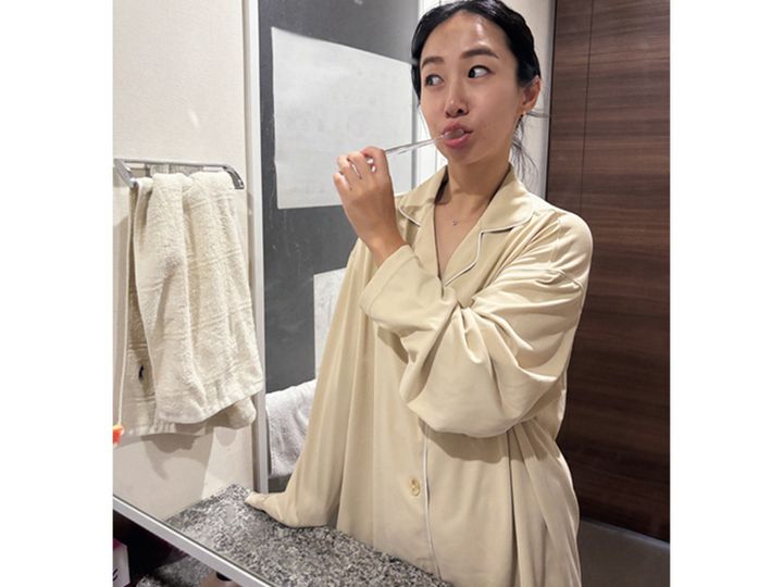 リカバリーウェアを着ながら歯磨きをするママ