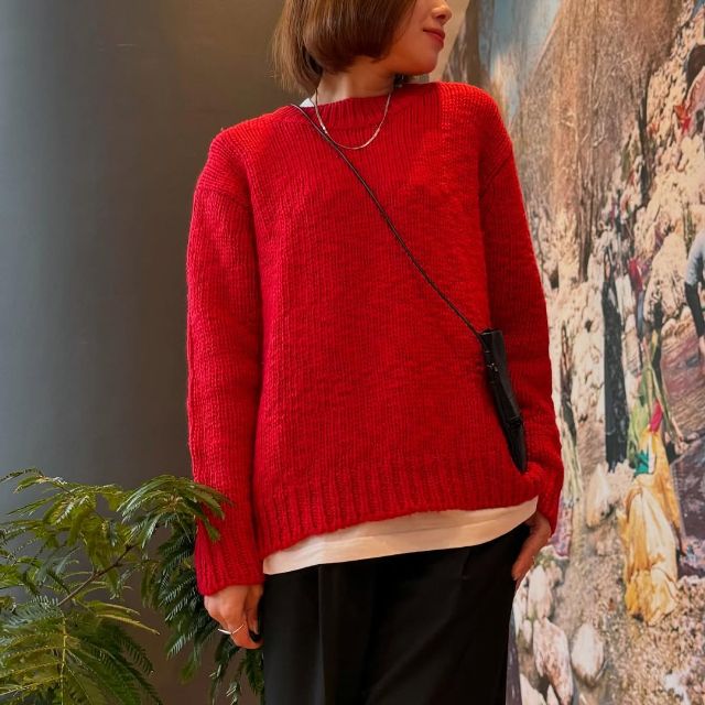 赤のウールローゲージクルーネックセーターを着たコーデ