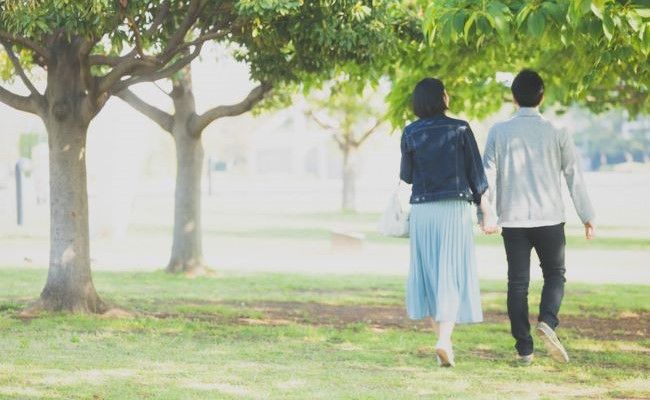 木陰を歩く夫婦の後ろ姿のイメージ