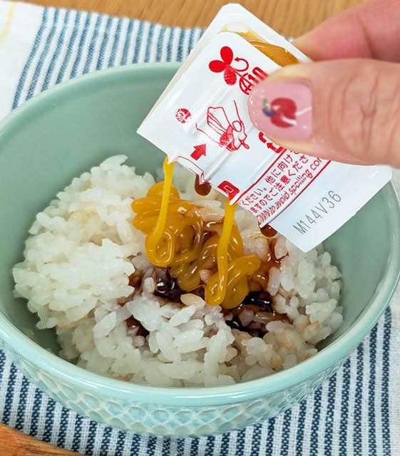 ドンキ「秒でどこでもTKG！？卵かけ風ご飯のたれ」をご飯にかけている様子