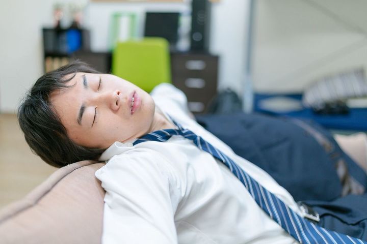 明かりをつけたままの部屋で寝落ちしている男性