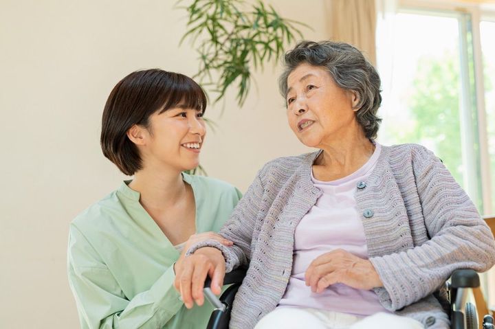 車椅子に座るシニア女性とその孫