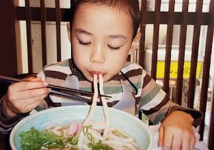 うどん店で食事を楽しむ息子（立石美津子さん提供）