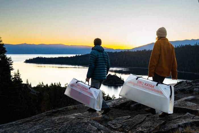折りたたんだORU KAYAKを持って湖へ向かう人
