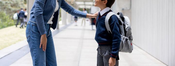 学校で息子を見送る笑顔の母親