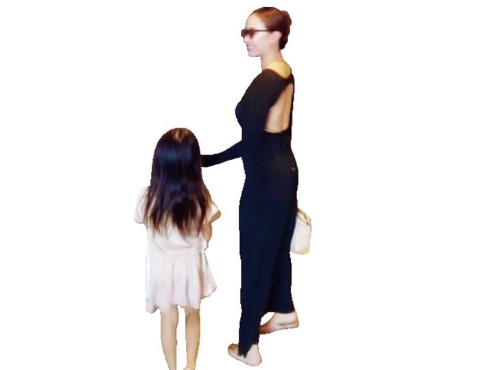 背中が空いた黒ワンピースを着た女性と子ども