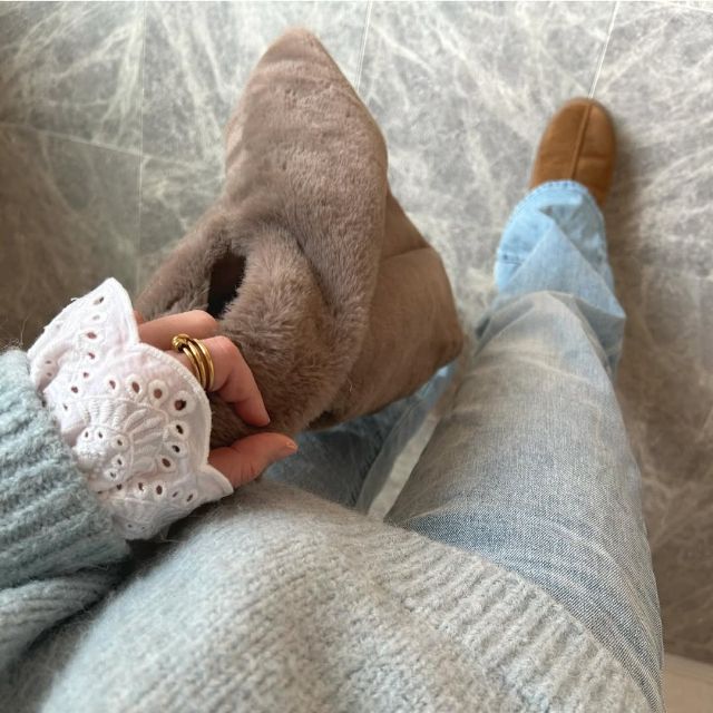 イギリス刺繍ディテールブラウスの袖先をセーターから少し出している