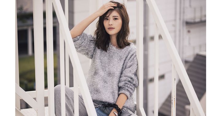 シルバーラメのシャギーニットとグレーのスウェットパンツのワントーンコーデに黒ブーツを合わせた着こなし