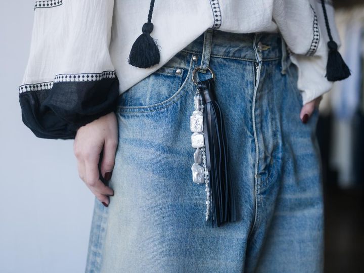 画像: ブラウスのブラックと同色にしたタッセルがスタイリングに調和 出典：ユナイテッドアローズ