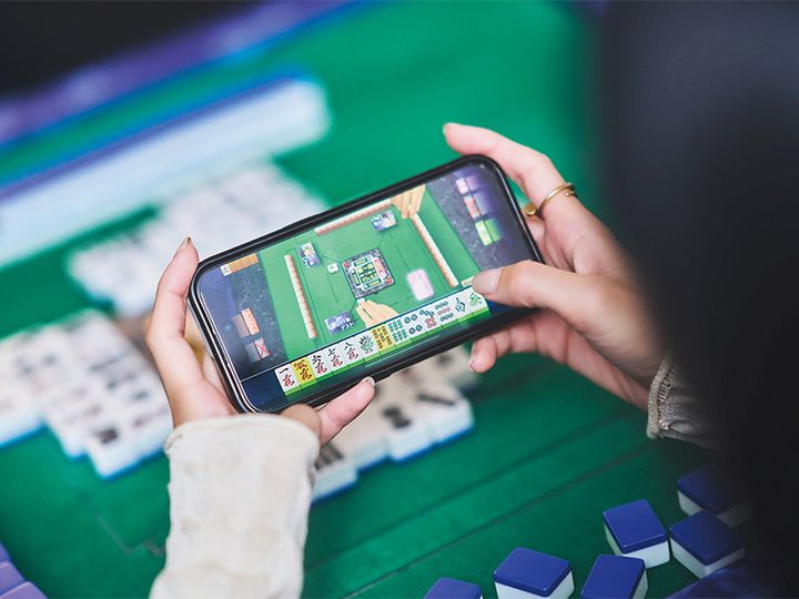 携帯で麻雀ゲームを楽しむ宮城舞さんの手元