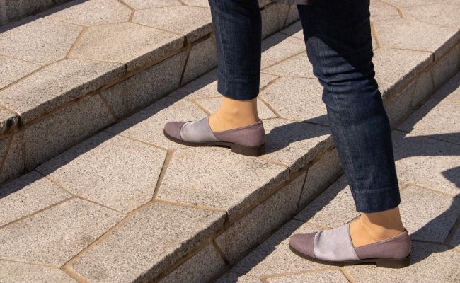 階段を登る女性の足元のイメージ